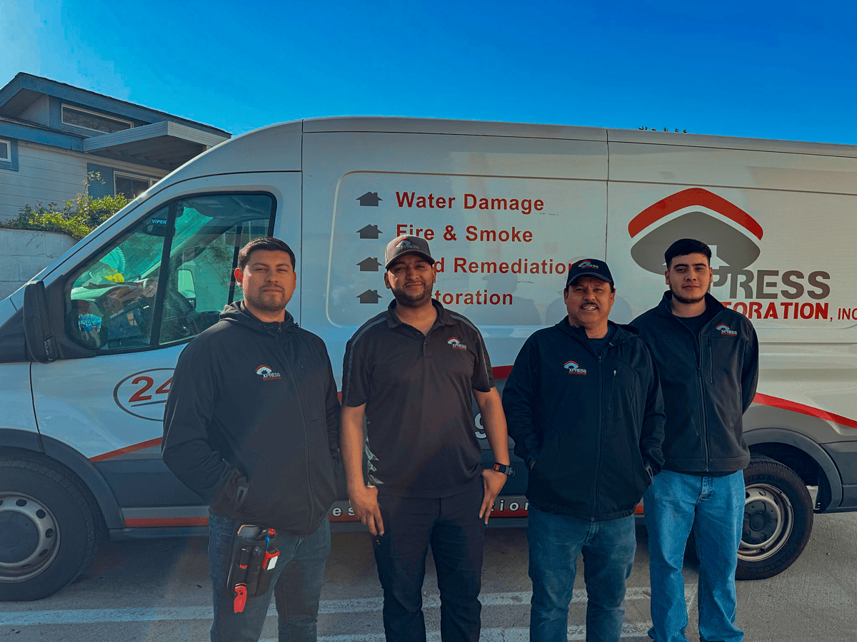 Team of Xpress Restoration Inc. standing in front of their service van, showcasing expertise in water damage and fire restoration services in Chula Vista.